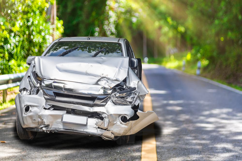 Morning Scene of a Light Gray Car with Severe Accident Damage on the Road, Parked and Waiting for the Insurance Officer.