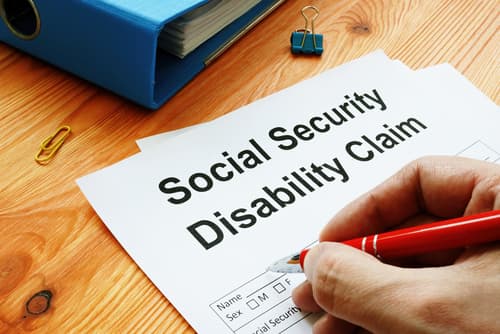 person filling out social security disability claim form