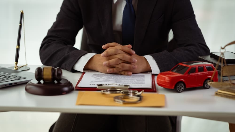 Insurance for court claims in the courtroom. Gavels and small toy car models represent two cars on the table in the court.